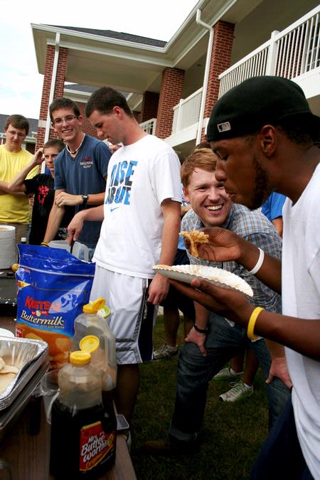 Luke Pruett, residence director, cheers on Michael Brown, sophomore social work major, during a pancake eating contest at the Watters Great Outdoors competition. - Photo by Deanna Santangelo