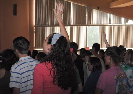 Students raise their hands in praise while singing in chapel. - Photo by Victoria Stargel