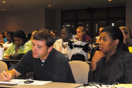 Greg Ginn and Veronica Morrow, both in the master of social work program, listen during the Social Justice Symposium.  - Photo by Victoria Stargel