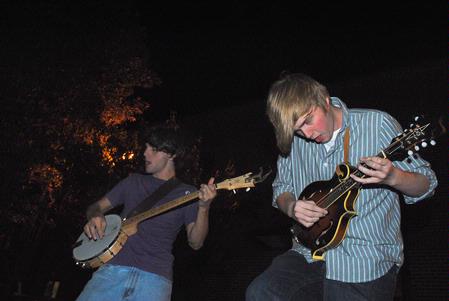 Freshmen English majors John Griffith and Austin Gray play the banjo and mandolin, respectively, for students in the Heritage Residence Complex after the Progressive Snacking event. - Photo by Victoria Stargel