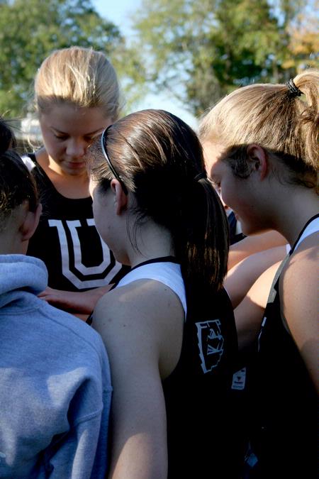 The women's cross country team gathers for a prayer after competing in a meet held on campus.  - Photo by Deanna Santangelo