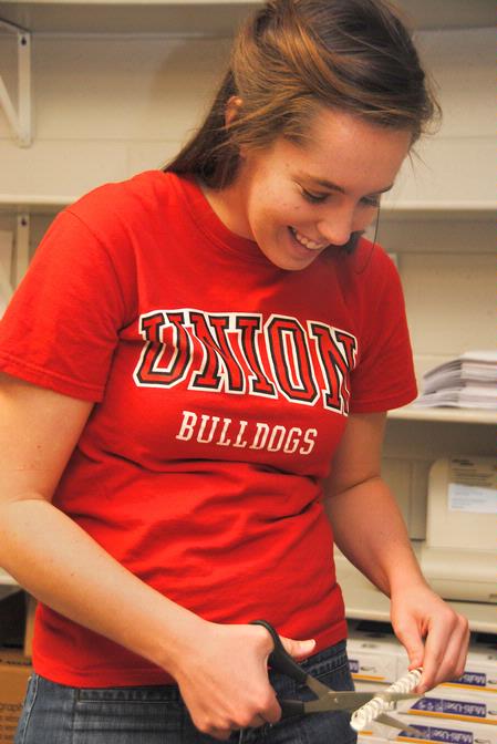 Jamie Mitchell, sophomore English major, clips binders for recipe books to be used as teacher appreciation gifts. Union's International Justice Mission chapter helped with this project at Thelma Barker Elementary School during Campus and Community Day. - Photo by Victoria Stargel