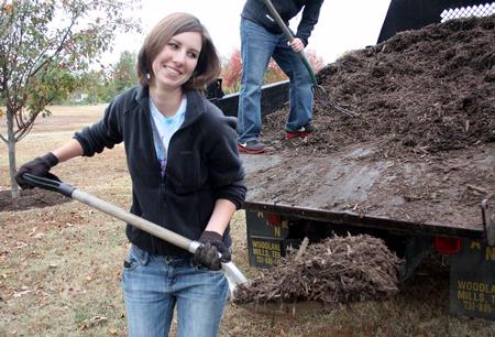 Laura Axelson, freshman elementary eduaction major, shovels mulch at Liberty Garden Park during Campus and Community Day.  - Photo by Ebbie Davis