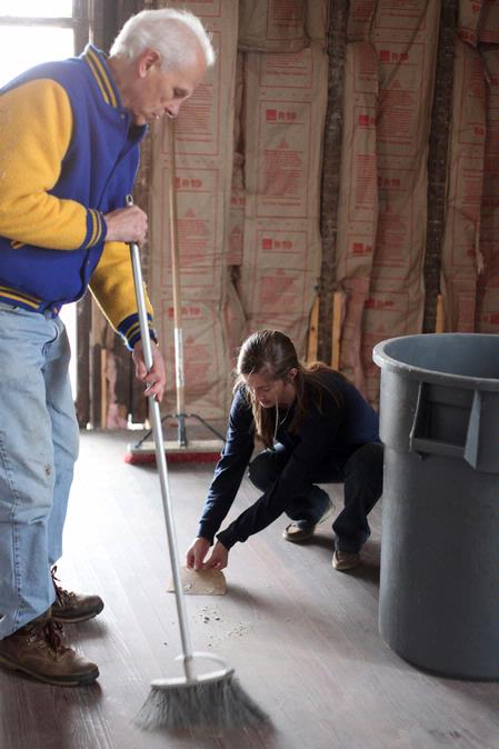 Stephen Carls, university professor of history and department chair, and Mary Ellen Poe, junior history major, sweep the floor of the Neil House, an 1800s home that has been relocated from Trenton, TN, to Casey Jones Village. The history department helped with the restoration as part of Campus and Community Day.  - Photo by Kristi McMurry Woody