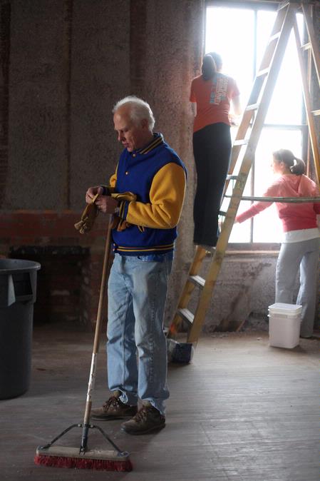 Stephen Carls, university professor of history and department chair, puts on gloves before getting back to work on the restoration of the Neil House, an 1800s home that is located at Casey Jones Village. The history department helped with the restoration as part of Campus and Community Day. - Photo by Kristi McMurry Woody