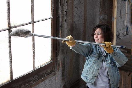 Camille McCullar, senior history major, dusts insulation from a window in the Neil House, an 1800s home that has been relocated to Casey Jones Village. The history department volunteered to help with the restoration process as a part of Campus and Community Day.  - Photo by Kristi McMurry Woody