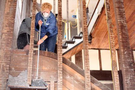 Elaura Highfield, junior history major, sweeps insulation at the 1800s home in Casey Jones Village. The Neil House was recently relocated from Trenton, TN, and the history department helped with the restoration process during Campus and Community Day.  - Photo by Kristi McMurry Woody
