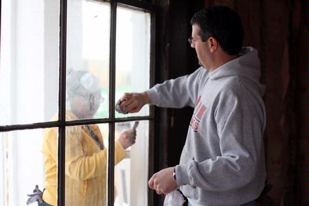 Glenae Nora, sophomore history major, and Keith Bates, associate professor of history, clean the windows of the Neil House, the 1800s home that was recently moved to Casey Jones Village to be restored. The history department volunteered to help on the restoration during Campus and Community Day.  - Photo by Kristi McMurry Woody