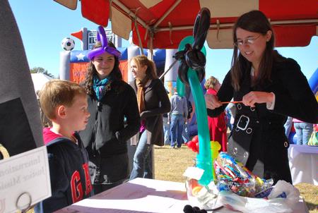 Rebekah Montgomery, senior physics major, makes balloon animals for children during Arts in the Park on the great lawn. All donations at the balloon booth went to the International Justice Mission. - Photo by Abigail Harris