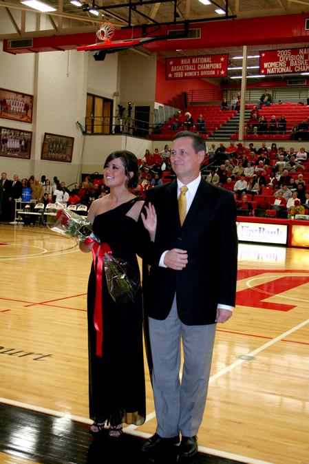 Kari Beougher, senior social work major, waves as she is escorted for the homecoming court during halftime of the Lady Bulldogs basketball game.  - Photo by Deanna Santangelo
