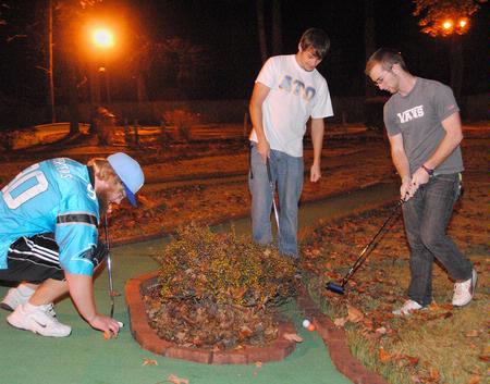 Seth Kincaid, junior mathmatics major, Patrick Jones, junior, and Josh Shell, sophomore Christian studies major, get ready to make their second putt during the Residence Life event, Puttapalooza. - Photo by Victoria Stargel