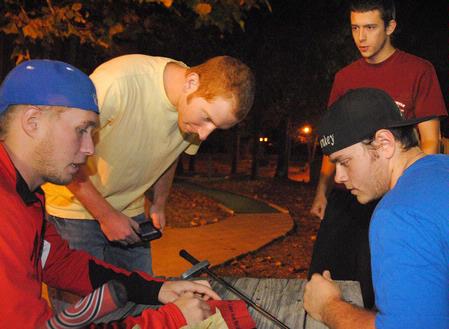 Jesper Swedenborg, Jeffrey Edwards, Casey Kidd, and Michael Forsythe check their putt-putt score at the Men's Residence Life event, Puttapalooza. - Photo by Victoria Stargel