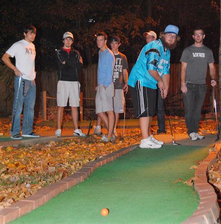 Seth Kincaid, junior mathematics major, putts toward the last hole as other players look on. Union Residence Life sponsored this men's event, Puttapalooza. - Photo by Victoria Stargel