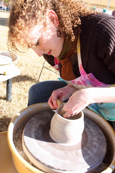 Rachel Moore, junior art major, throws a cup on the wheel at Arts in the Park, a homecoming event.  - Photo by Ebbie Davis