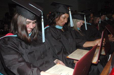 Graduates eagerly open their diplomas after receiving them at the 2010 Fall Commencement Services.  - Photo by Beth Spain