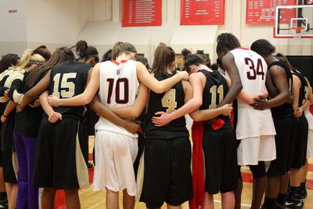 The Lady Bulldogs and opponents Bethel University join together in prayer after their game, which The Lady Bulldogs won 81-62. - Photo by Ebbie Davis