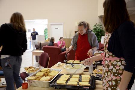 Megan Bailey, junior intercultural studies major, helps make food during the President's Day welcome back breakfast.  - Photo by Abigail Harris