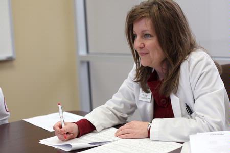 Kimberly Lindsey, assistant professor of pharmacy practice, takes notes on student presentations during class.  - Photo by Kristi McMurry Woody