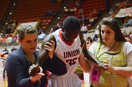 After an injury, Mildred Olumasi is assisted off the court with only a couple of minutes left in the first game of the NAIA National Championships. The Lady Bulldogs won the game 62-37. - Photo by Beth Spain