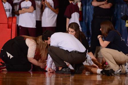 Mark Campbell, head coach, and others check on LaTesa McLaughlin after an injury in game two of the NAIA National Championship.  - Photo by Morris Abernathy