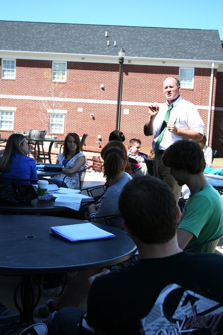 Brad Green, associate professor of Christian thought and tradition, teaches his class on the Barefoots Joe patio on a beautiful day. - Photo by Deanna Santangelo