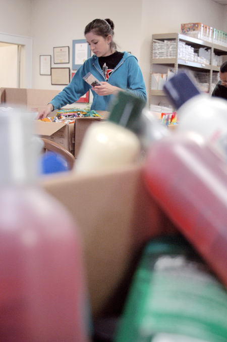 Sophomore Laura Berkemeyer, art major, sorts through boxes of donations at the Red Cross during the Day of Remembrance. - Photo by Lindsay Stavish