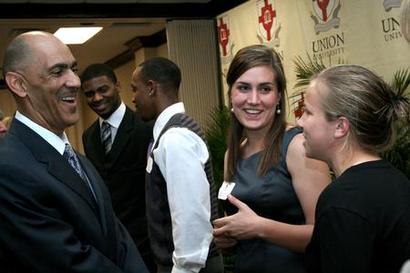 Tony Dungy, Super Bowl winning coach, greets Amber Lovelady, senior political science, and Dionna Linn, freshman athletic training, during the Roy L. White Golf and Gala meet and greet time.  - Photo by Deanna Santangelo