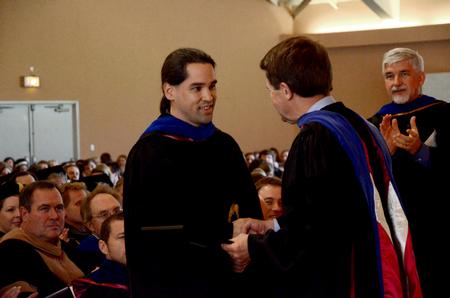 Fonsie Guilaran, associate professor of physics, receives the Howard Newell Innovative Teaching Award from Howard Newell, professor of business administration, during Awards Day chapel. - Photo by Deanna Santangelo