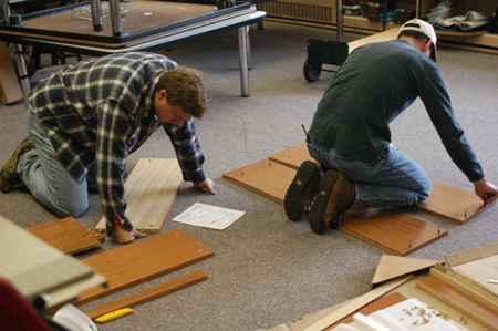 Junior Tim Hopper and Chemistry professor Michael Salazar work together to build shelves for a new science lab at Parkview Montessori Elementary School during Day of Remembrance 2003. - Photo by Jonathan Blair