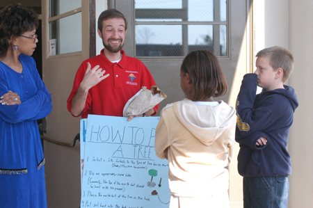 Senior Biology major Michael Kieffer explains the process of planting trees to Parkview Montessori students and Principal Virginia Stakens-Crump during Day of Remembrance 2003. - Photo by Jonathan Blair