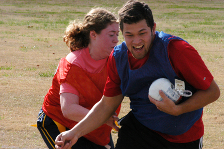 Sophomore Rickey Lopez tries to get away from fellow Sophomore Donna Reed's attempt at pulling his flags during the Young Alum sponsored Turkey Bowl. - Photo by Jonathan Blair