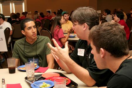 Chris Blair, associate professor of communication arts, talks with new student during Dinner with your Department in the Carl Grant Event Center. - Photo by Deanna Santangelo