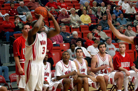 Senior guard Chima Abakwue (3) prepares to take a shot in the game versus Lyon College as bench follows the action.
 - Photo by Jonathan Blair