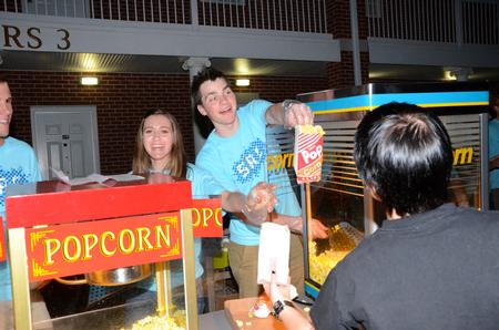 Matt Parker, senior business major, serves popcorn before Movie on the Lawn, hosted by SAC in the Watters quad.  - Photo by Ebbie Davis