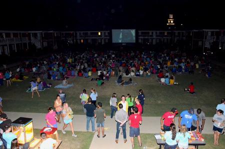 Students enjoy a movie during Movie on the Lawn while members of SAC serve popcorn, drinks, and candy.  - Photo by Ebbie Davis