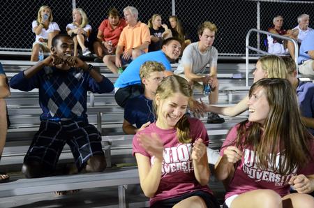 Ruth Bone, freshman biology/pre-med major, laughs at Denis Bisangwa, freshman business administration, as he dances during half time at a match between Union University's men's soccer team and Notre Dame College.  - Photo by Zac Calvert