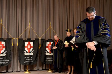 Keith Bates, associate professor of history and faculty member of the year, along with fellow, faculty, staff and students gather together to pray during Convocation. - Photo by Ebbie Davis