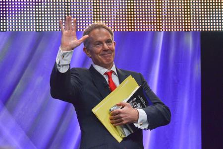Former British Prime Minister Tony Blair waves to the audience after his speech. Blair spoke of his efforts in the Middle East to secure a lasting peace. - Photo by Morris Abernathy