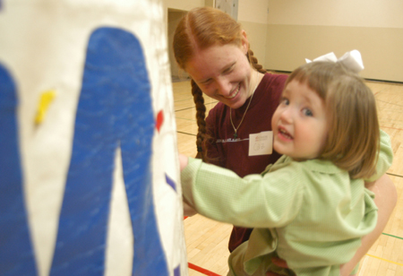 Junior Rachel Cazalas negotiates dande jumper time with a Homecoming Day Camp participant. - Photo by Jonathan Blair