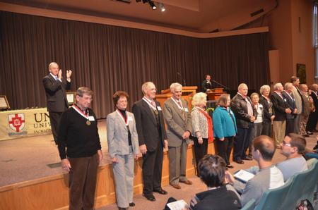 After honoring the class of 1962, David S. Dockery, president of the university, leads chapel attendees in a round of applause. - Photo by Morris Abernathy