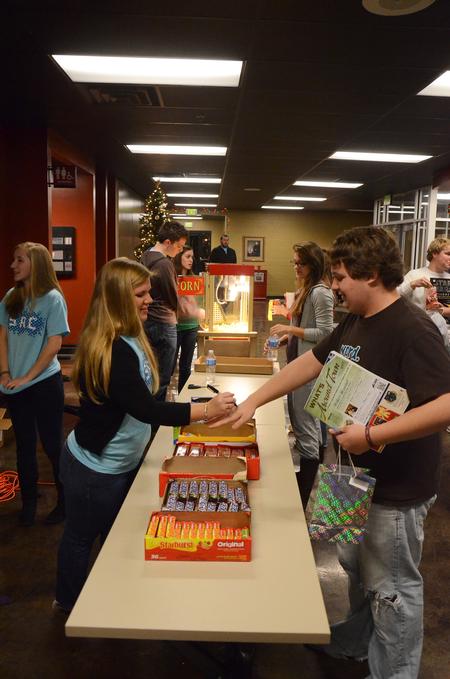 Doug May, freshman music education major, picks up some candy from a member of SAC before How the Grinch Stole Christmas for Movie in the Bowld. - Photo by Zac Calvert