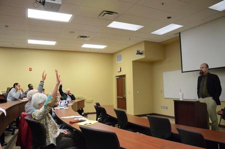 Micah Watson, assistant professor of political science, asks for crowd participation during a discussion on the drastic changes of American politics and the splinter effect of news and media during a Town & Gown session in Providence Hall. - Photo by Zac Calvert