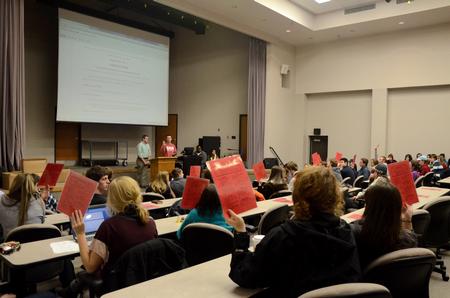 Students vote on a bill during the Student Senate meeting in Harvey Auditorium. - Photo by Anne Richoux