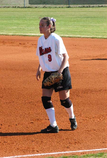 Senior Christina Johnson (9) stands ready at first base as she awaits the pitch to the plate. - Photo by Steven Aldridge