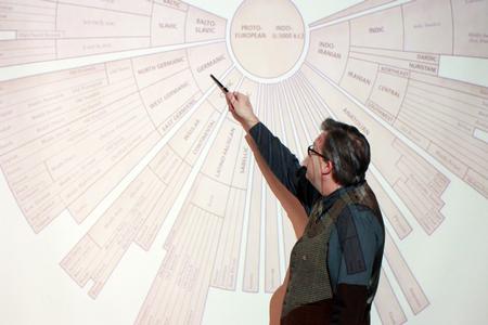 Gavin Richardson, professor of English, points out the subject for the day's class on a languages diagram. - Photo by Kristi McMurry Woody