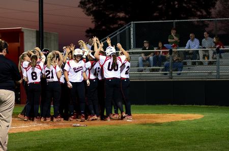 The Lady Bulldog softball team celebrates with Jenyce Spence (middle) after her home-run during a double-header against Freed-Hardeman University. - Photo by Anne Richoux