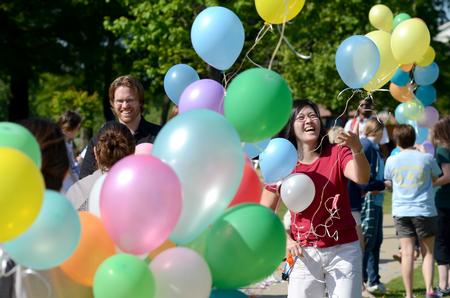 Steve Halla and Haelim Allen, assistant professors of art, help take down an arch of more than 1,600 balloons that floated over campus. - Photo by Jacob Moore
