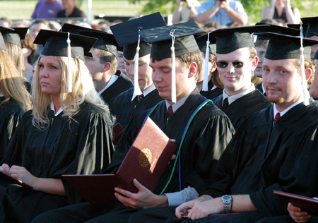 Broadcasting graduate Patrick Compau takes a first look at his diploma at spring commencement. - Photo by Kristen Hiller