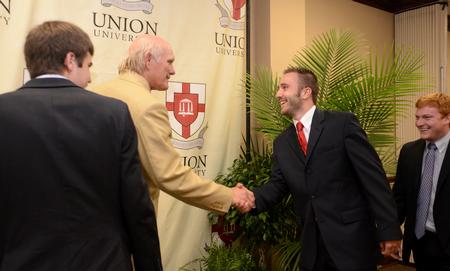 Buckley Parker, senior biology major, greets Terry Bradshaw, former NFL quarterback and current FOX Sports analyst, after the fourth annual Roy L. White Legacy Golf & Gala. - Photo by Jacob Moore