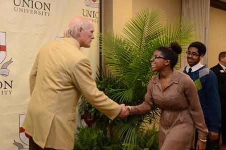 Darcie Williams, junior psychology major, greets Terry Bradshaw, former NFL quarterback and current FOX Sports analyst, after the fourth annual Roy L. White Legacy Golf & Gala. - Photo by Jacob Moore